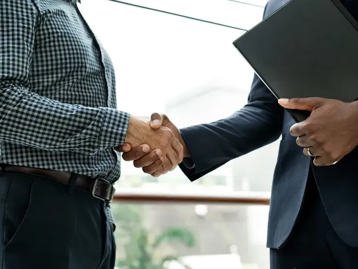 Two professionals shaking hands after a meeting, illustrating successful local partnerships on City Business Hub